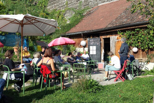 Menschen sitzen im Stiftsgarten.